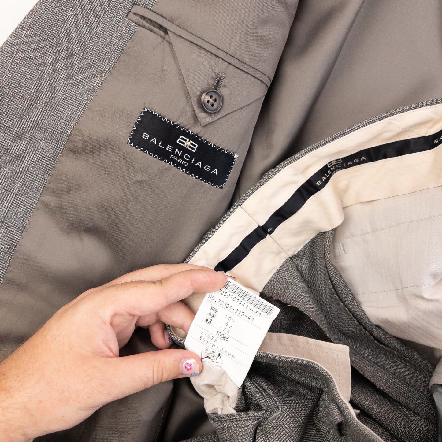 BALENCIAGA grey checkered suit set featuring a two-button jacket with flap pockets and pleated trousers