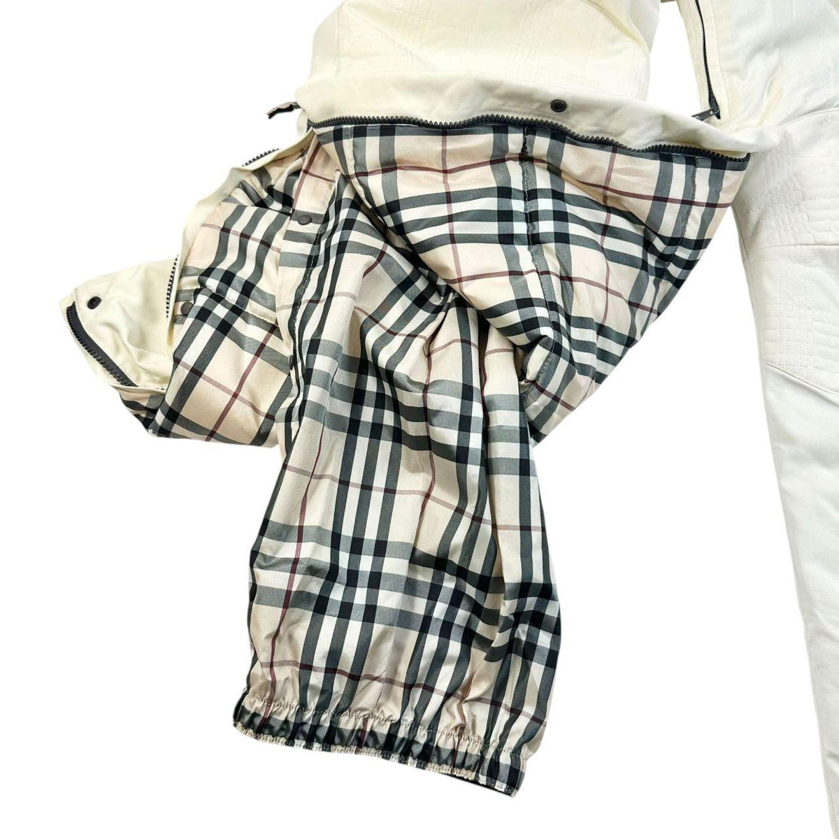 Burberry white ski overalls with logo detail on chest and adjustable straps.