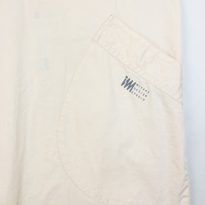 ISSEY MIYAKE beige apron with crossed back straps and stamped logo pocket detail