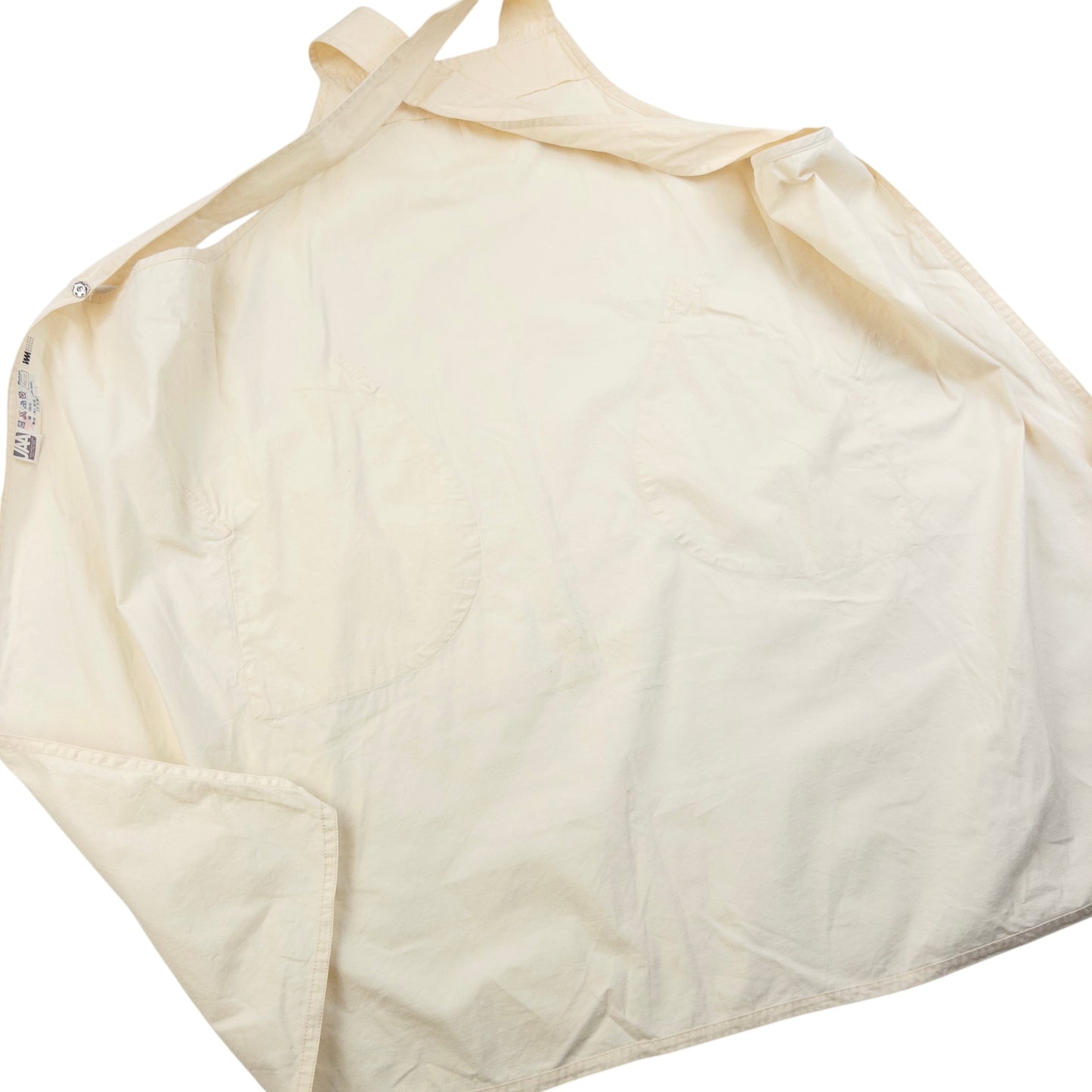 ISSEY MIYAKE beige apron with crossed back straps and stamped logo pocket detail