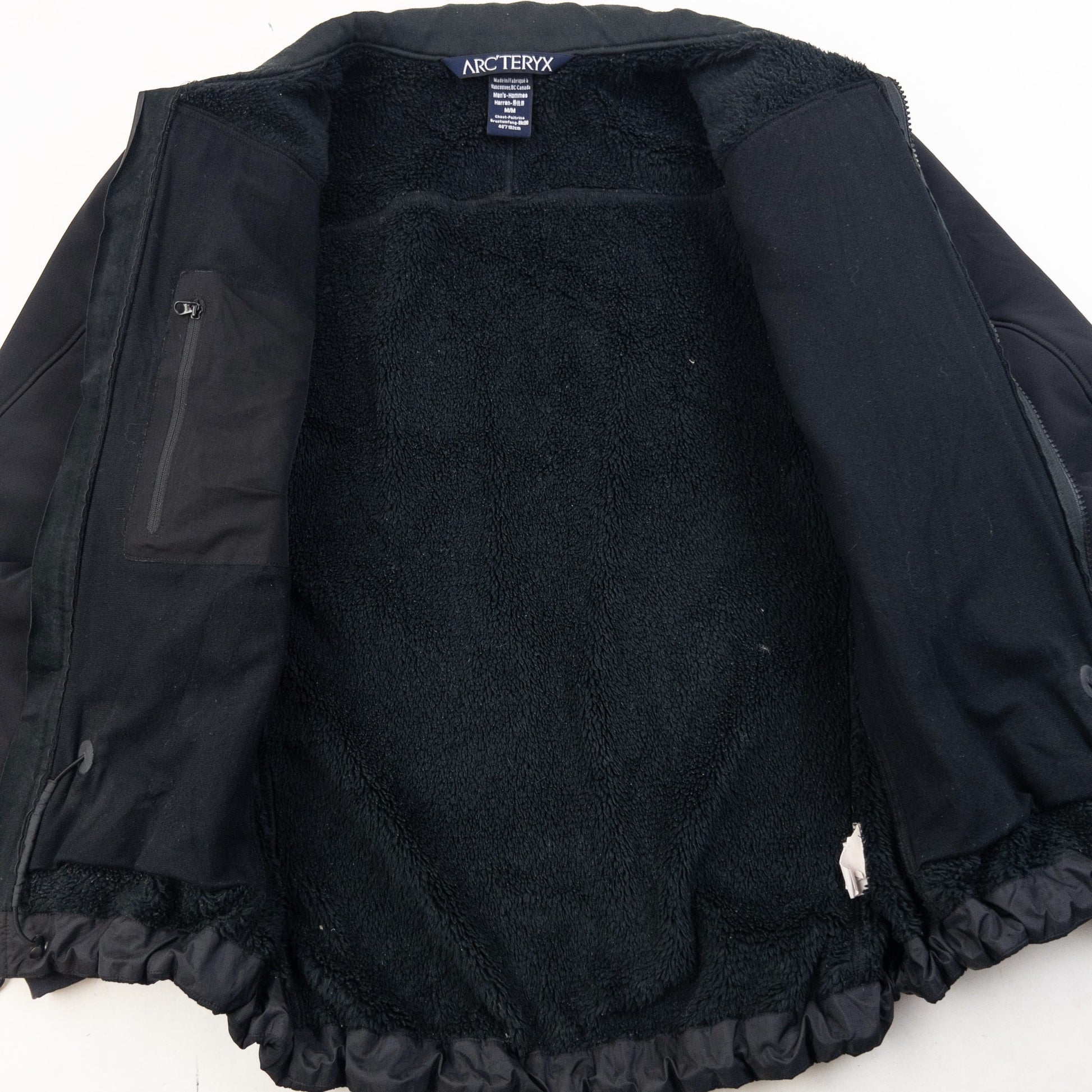 ARCTERYX black fleece jacket with embroidered logo on chest and zippered pockets.