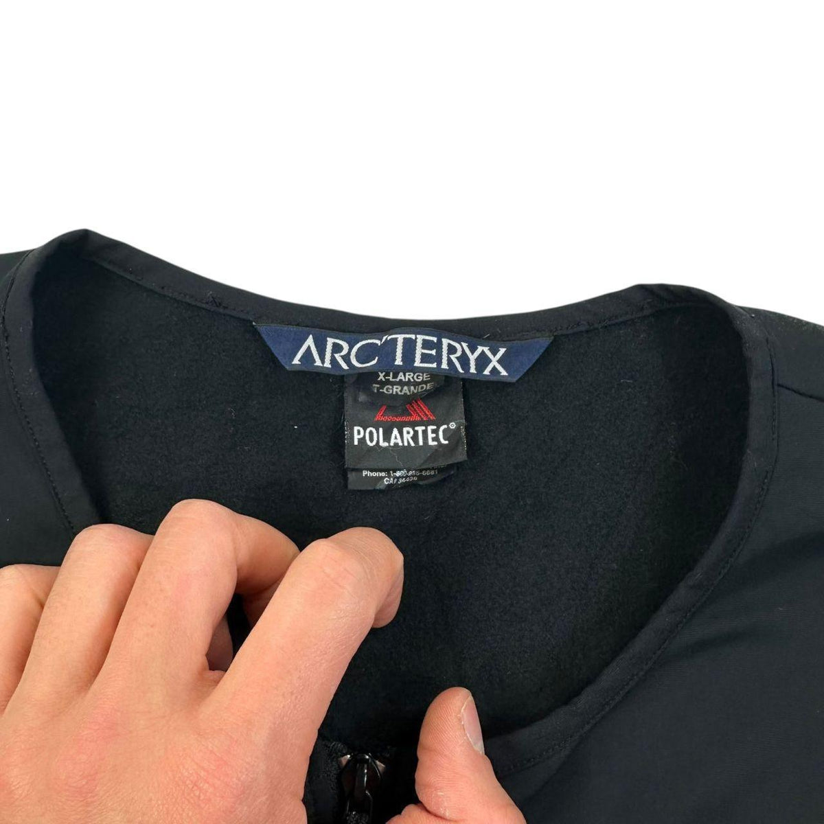 ARCTERYX black lightweight zip-up jumpsuit with distinctive logo on chest and zippered pockets.