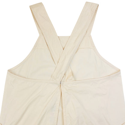 ISSEY MIYAKE beige apron with crossed back straps and stamped logo pocket detail