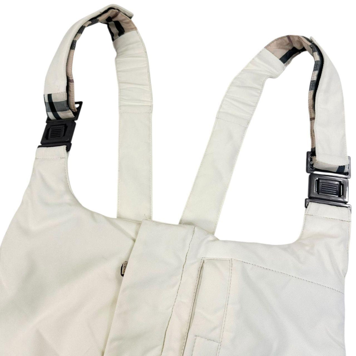Burberry white ski overalls with logo detail on chest and adjustable straps.