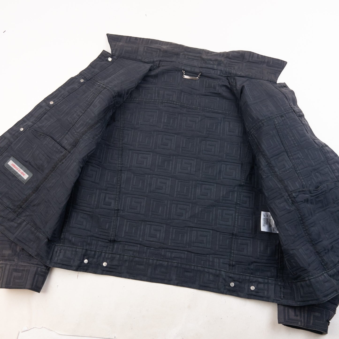 Versace Classic black button-up jacket embossed geometric pattern and branded metal buttons.