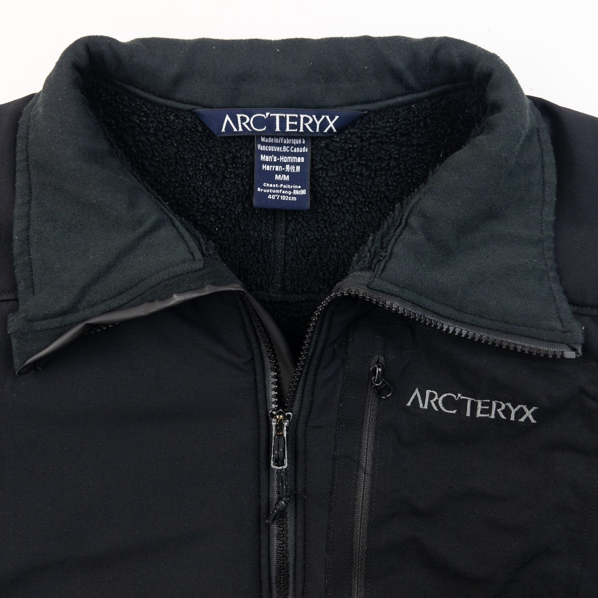 ARCTERYX black fleece jacket with embroidered logo on chest and zippered pockets.