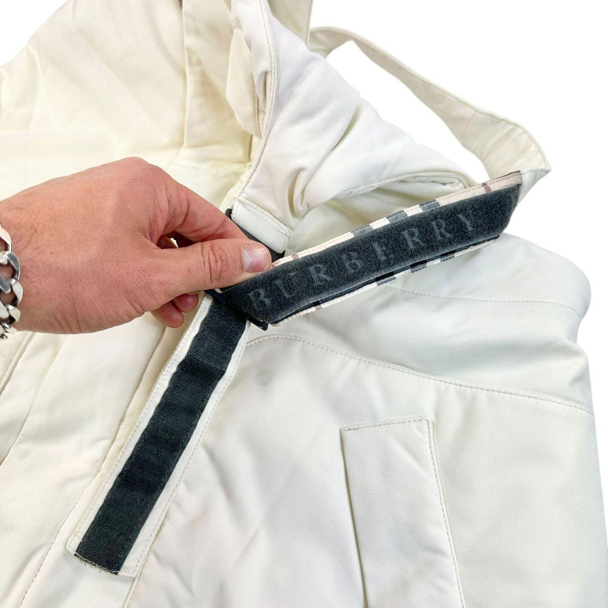 Burberry white ski overalls with logo detail on chest and adjustable straps.
