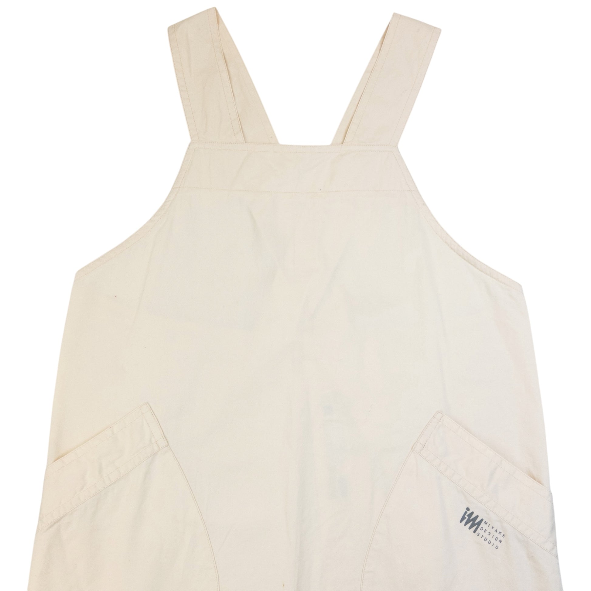 ISSEY MIYAKE beige apron with crossed back straps and stamped logo pocket detail