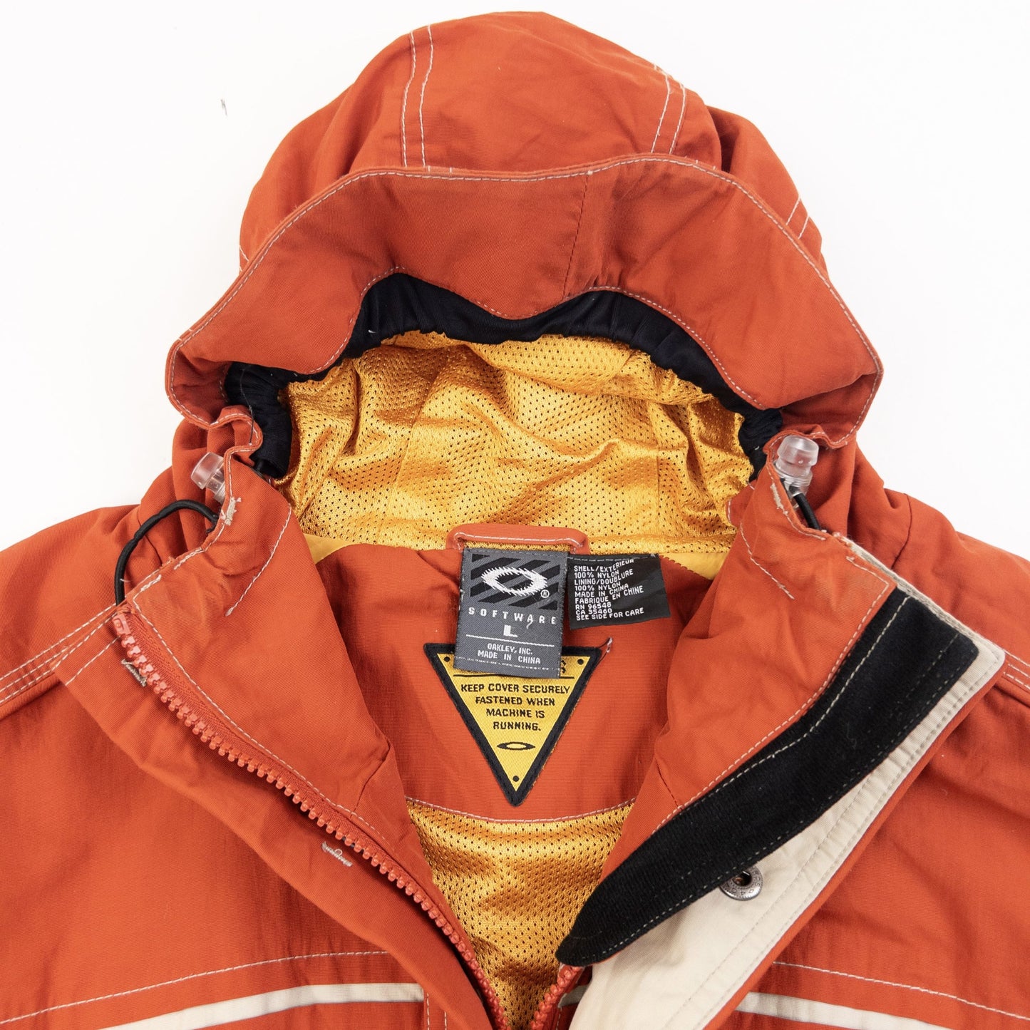OAKLEY orange zip-up snowboarding jacket with reflective strip detail on chest and hood.