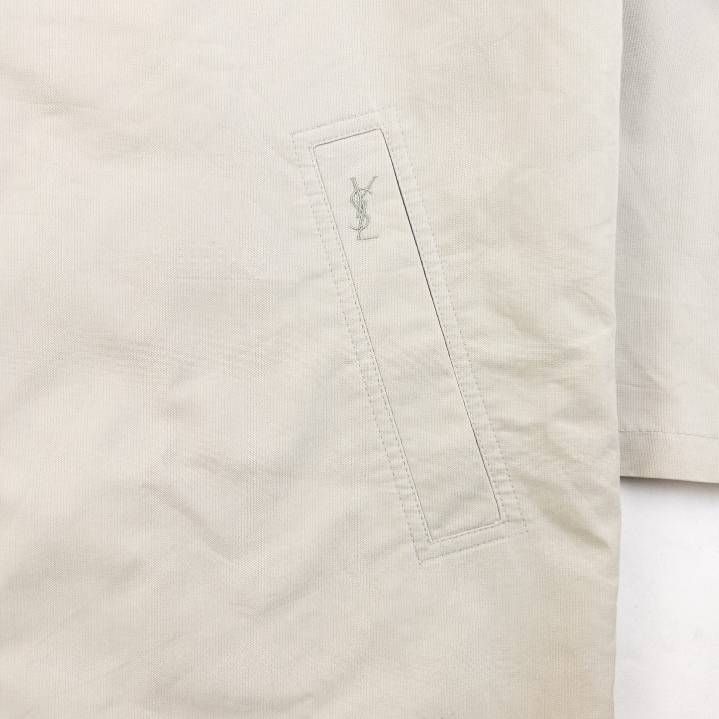 YVES SAINT LAURENT beige Harrington jacket with YSL embroidery on pocket and checkered lining.